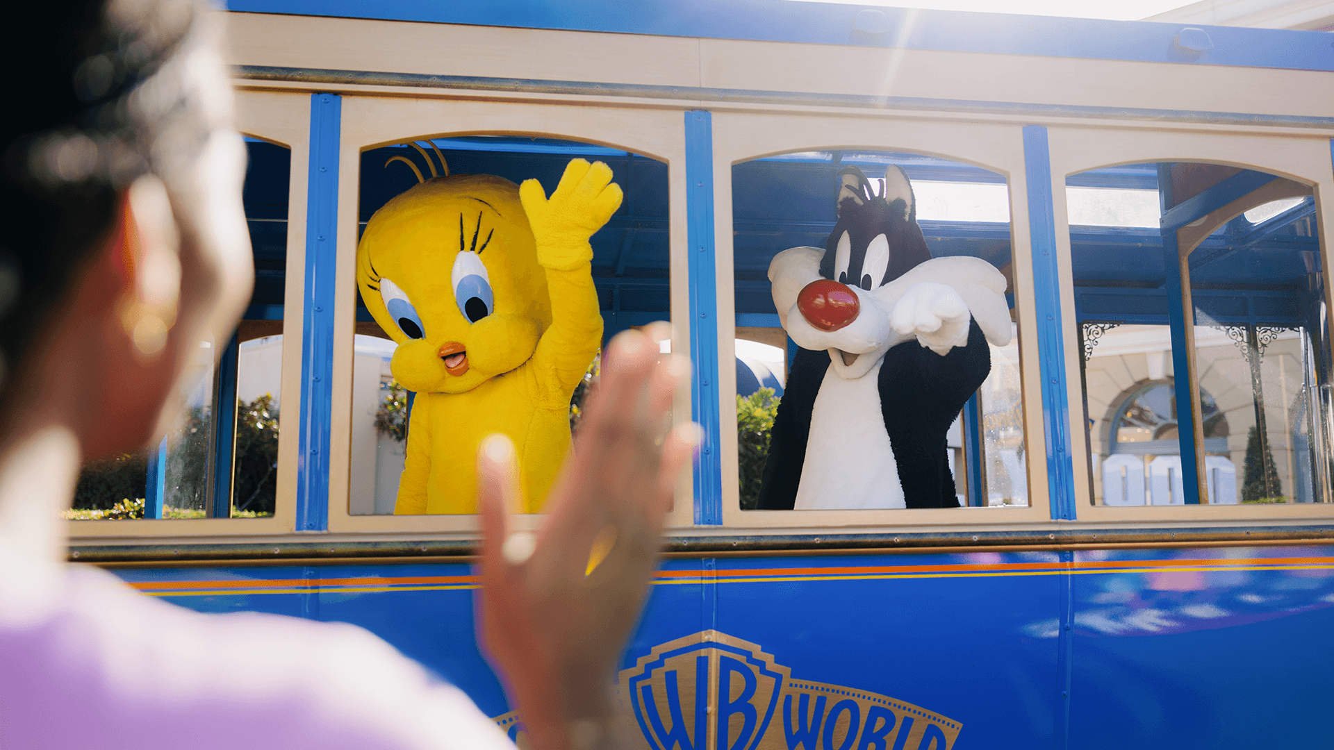 Tweety and Sylvester waving at an audience member during the Star Parade at Warner Bros. Movie World